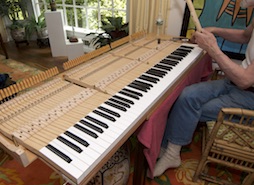 Terry Flynn working on lowering friction of keys of a grand piano.