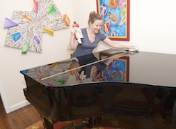 Iris Tuomenoksa polishing up  a Yamaha piano for sale.